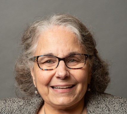 A smiling headshot of Ellem Miseo on a professional background